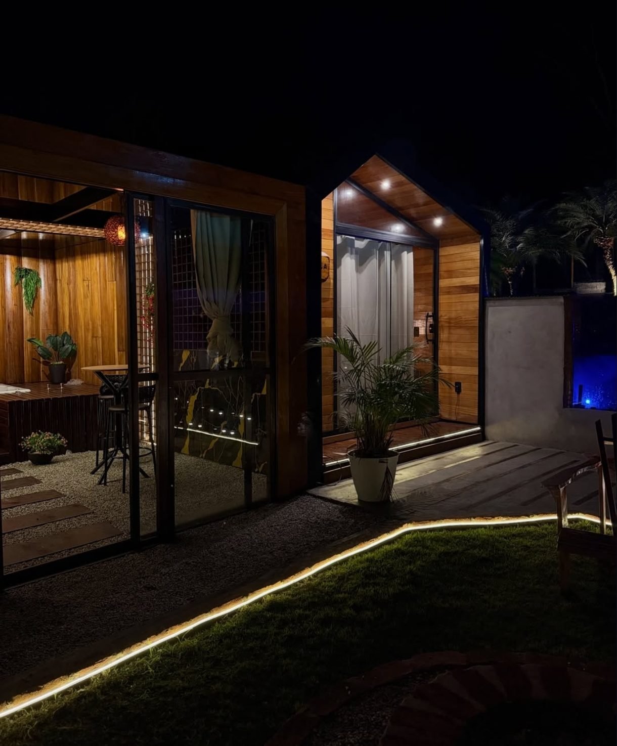 Vista externa dos Chalés Boa União à noite, com fachadas em madeira iluminadas